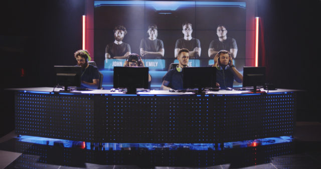 Medium close-up of a team sitting down at their computers at a gaming tournament